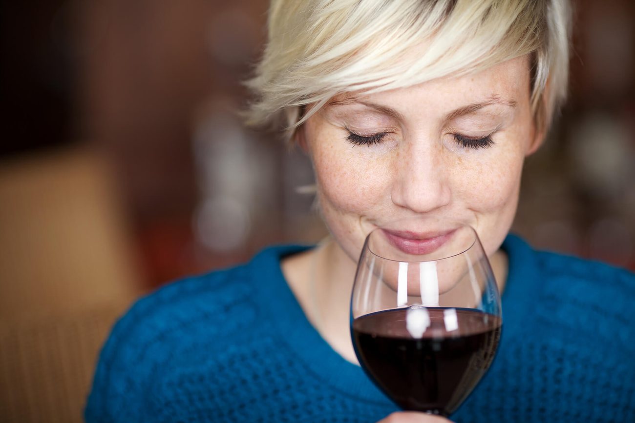 Eine Frau genießt ein Glas Rotwein des Weinguts Knapp